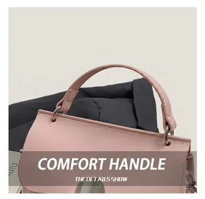 Detail of the soft pink leather handbag featuring a smooth handle and metal ring connector