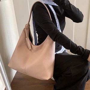 Pink lychee texture leather tote bag with large capacity shown in a side view on model