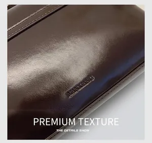 Gros plan sur la texture du cuir ciré et la gravure de marque sur le sac marron