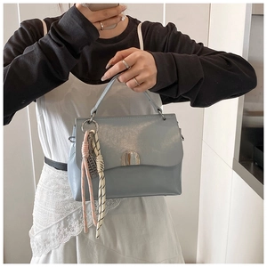 Macro shot of light blue PU leather tote with silver lock and woven rope detail