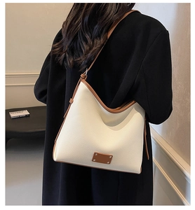 Close-up of white lychee pattern hobo bag with brown contrast leather trim and stitching