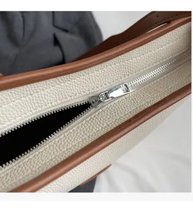 Detail of the high-quality silver metal zipper on the lychee grain leather tote bag