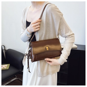 Détail d'un sac porté épaule en cuir ciré vintage avec fermoir rotatif en métal doré