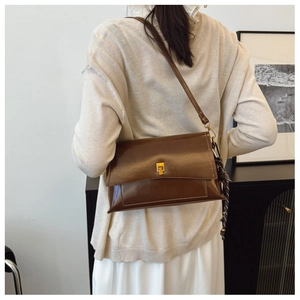 Sac bandoulière en cuir ciré marron avec boucle dorée et détail de foulard à pois