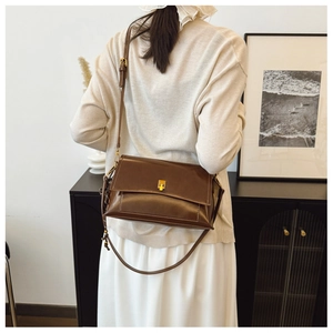Détail du sac à bandoulière vintage en cuir huilé marron avec boucle en métal doré
