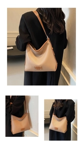 Detailed macro view of khaki pebbled leather tote bag with brown rivet corner patches