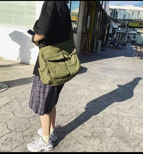 Army green canvas crossbody bag featuring large capacity and dual front flap pockets