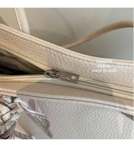 Detail of smooth silver zipper and printed silk scarf on textured leather tote bag