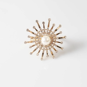 Elegant gold flower napkin ring with central pearl and sparkling crystal accents