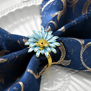 Dettaglio portatovagliolo con girasole blu e ape su tessuto damascato blu con tocchi d'oro