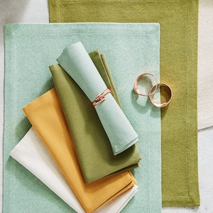 Rose gold polished round metal napkin rings set with colorful cotton linen napkins