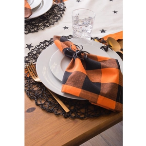 Detail of a black spider napkin ring on orange buffalo plaid napkin for Halloween decor
