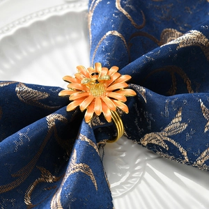 Rond de serviette marguerite orange avec abeille dorée sur serviette bleue