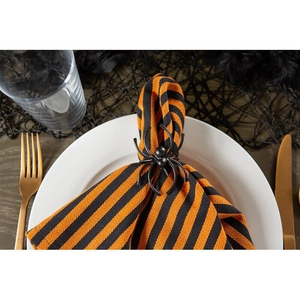 Detailed close-up of a black spider napkin ring on a festive Halloween striped napkin