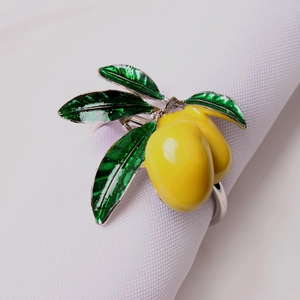 Detalle de servilletero de limón amarillo con hojas verdes en servilleta blanca