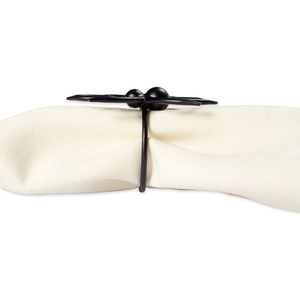 Close-up of matte black metal spider napkin ring with textured legs on white cloth