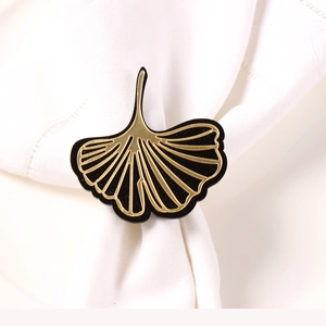 Elegant ginkgo leaf napkin ring with golden veins on black surface for table decor