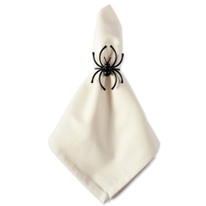 Detailed view of a black spider napkin ring on a beige fabric napkin for Halloween decor