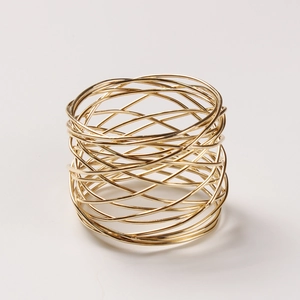Detailed top view of golden metal wire napkin ring with minimalist mesh wrap design