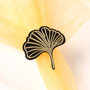 Macro shot of ginkgo leaf napkin ring with gold veins and black finish on tulle