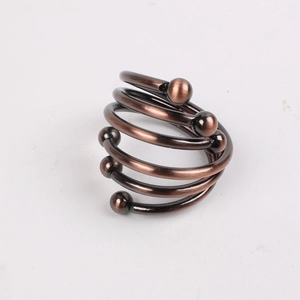 Detailed close-up of a spiral gold napkin ring featuring elegant six-bead metallic accents