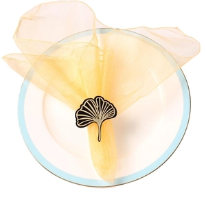 Elegant gold-edged ginkgo leaf napkin ring with black enamel finish on white plate