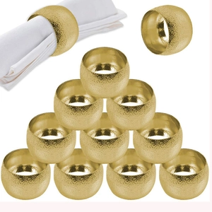 Détail de 12 ronds de serviette dorés en forme de tambour avec texture métallique mate