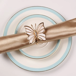 Golden butterfly napkin ring with white shell wings and sparkling crystal accents