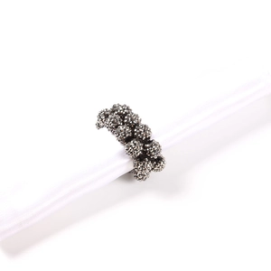 Macro shot of dark grey beaded napkin ring with faceted crystal clusters on white silk