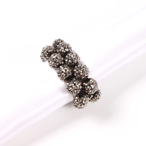 Handmade beaded napkin ring with sparkling rhinestone spheres on elegant white satin roll