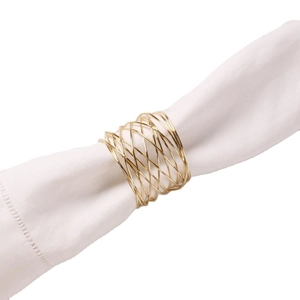 Portatovaglioli minimalista in filo dorato con design a spirale su tessuto bianco