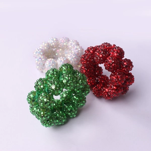 Close-up of handmade beaded napkin rings with sparkling rhinestones in red and green
