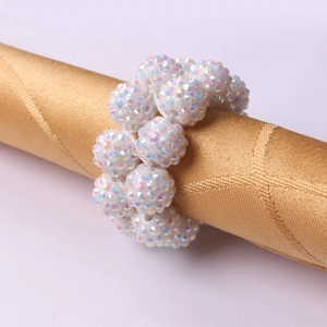 Close-up of handmade napkin ring with AB crystal beads on a golden satin fabric