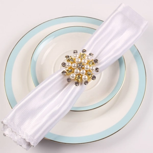 Eleganter Serviettenring mit Perlen und Strasssteinen in Blumenform für festliche Tische