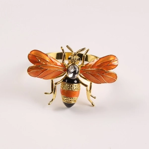 Macro detail of yellow bee napkin ring with orange enamel and crystal inlay decoration