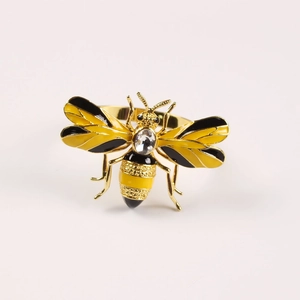 Detail showing the gold bee napkin ring with yellow enamel and a large sparkling crystal