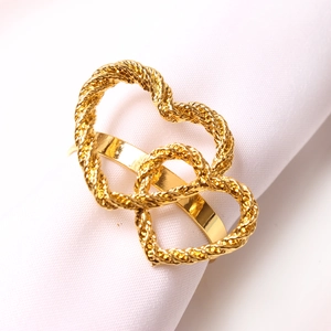 Gold double heart napkin ring with twisted rope texture on elegant white fabric