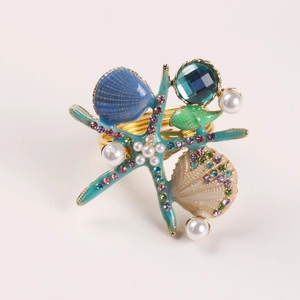 Détails d'un rond de serviette étoile de mer et coquillage avec perles et cristaux