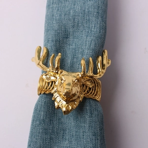 Rond de serviette tête de cerf doré avec base à ressort sur tissu bleu foncé