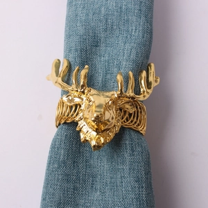 Détail d'un rond de serviette tête de cerf doré avec bois sur tissu bleu foncé