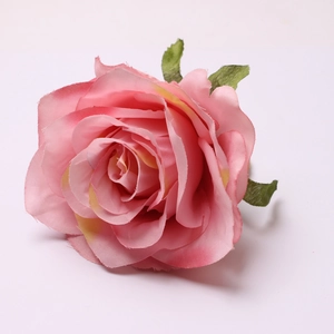 Macro detail of artificial pink silk rose flower head with multi-layered realistic petals