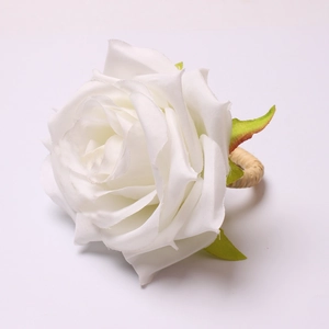 Detail of white silk rose napkin ring with a natural woven grass circular base