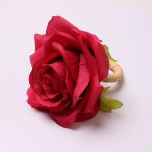 Macro detail of artificial red rose napkin ring with realistic silk petals and woven base
