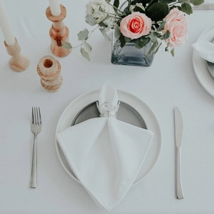 Silver crown napkin ring with hollow engravings on elegant table with white linen