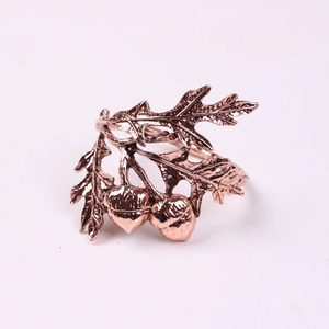Detailed close-up of rose gold napkin rings featuring realistic oak leaf and acorn motifs