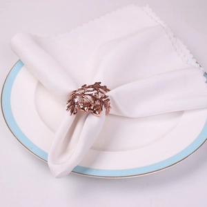Detail of rose gold acorn and leaf napkin ring on a white cloth for table decor