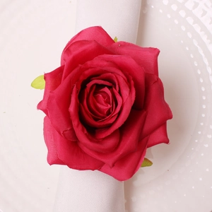 Detailed top view of realistic red silk rose napkin ring on a white dotted plate