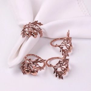 Detail of rose gold acorn and leaf napkin rings showing intricate metal textures
