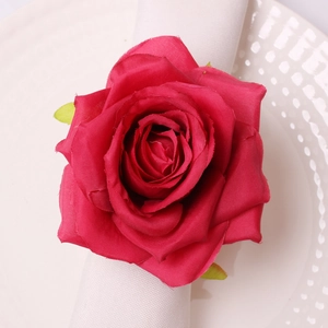 Detailed top view of a realistic red silk rose napkin ring on a white plate and cloth