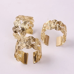Close-up of golden woven wire napkin rings showing detailed metal mesh texture